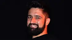 Ritratto sorridente di Gio Juan, insegnante di salsa cubana presso Il Mosaico Danza a Milano, con maglietta nera e sfondo scuro brandizzato